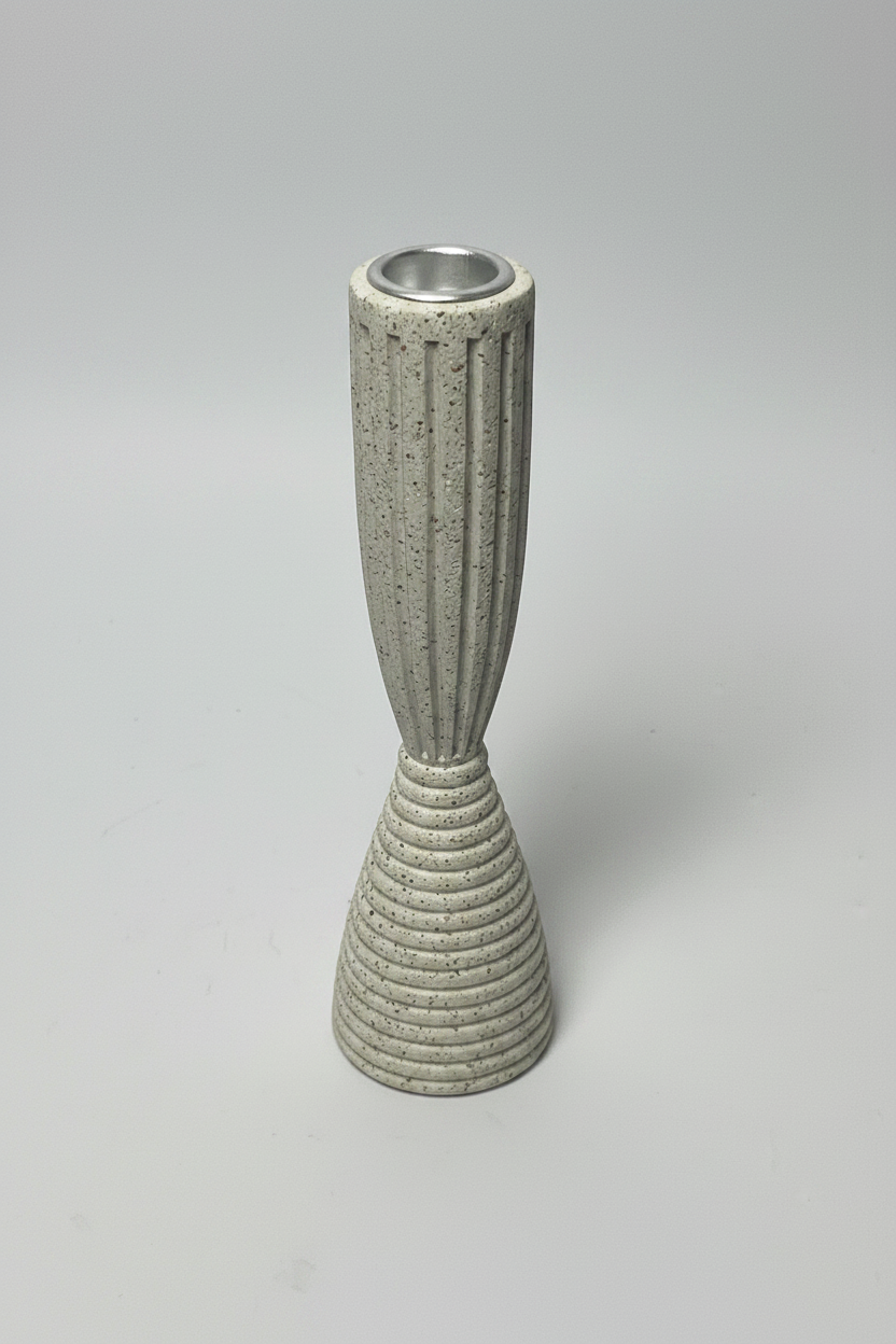 A modern ceramic candle holder with a fluted upper section and a ribbed conical base, in a speckled light gray glaze with a silver metal rim at the top, set against a neutral light gray background.